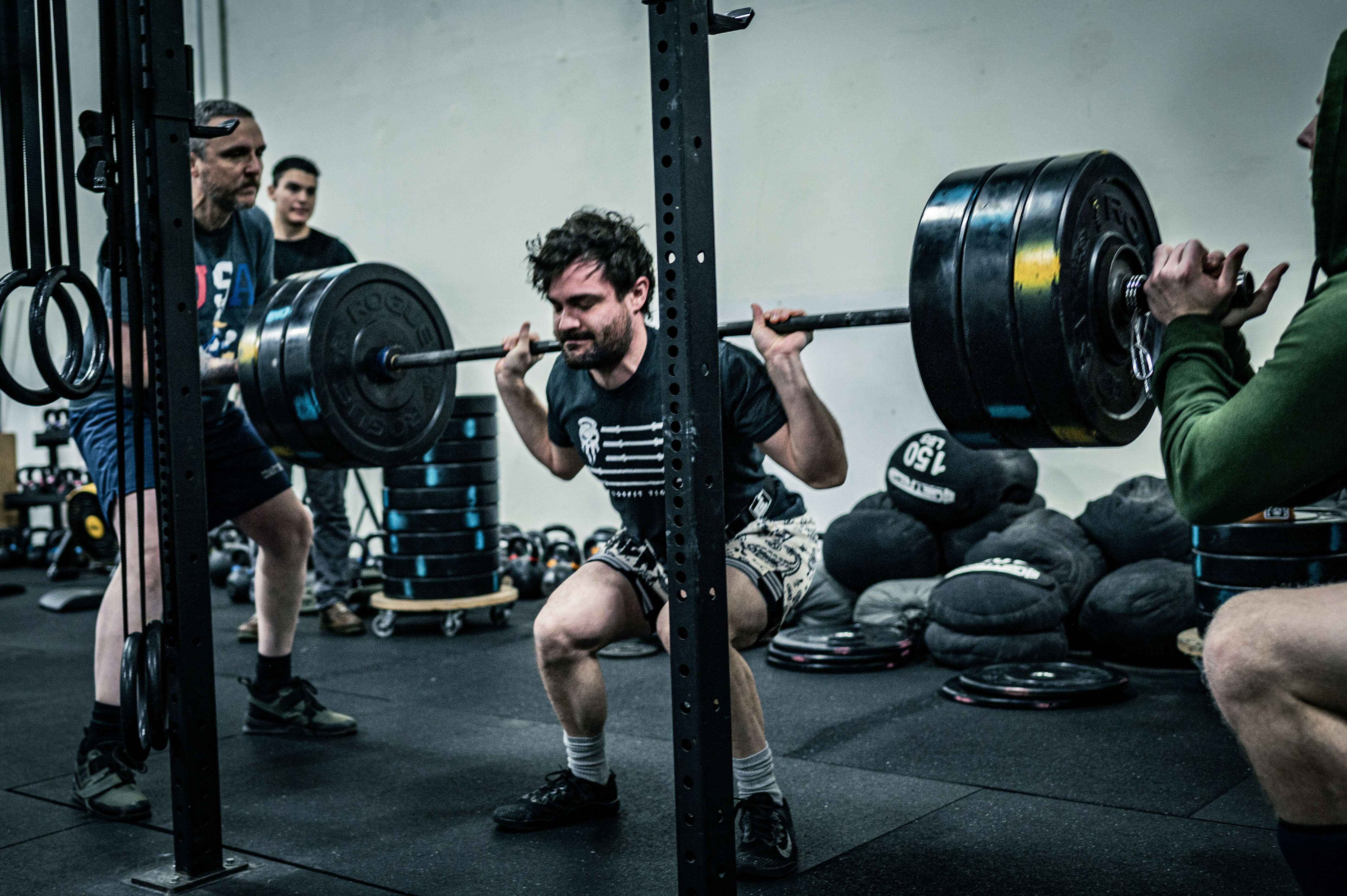 CrossFit Tigard athlete performing heavy barbell squat during group class